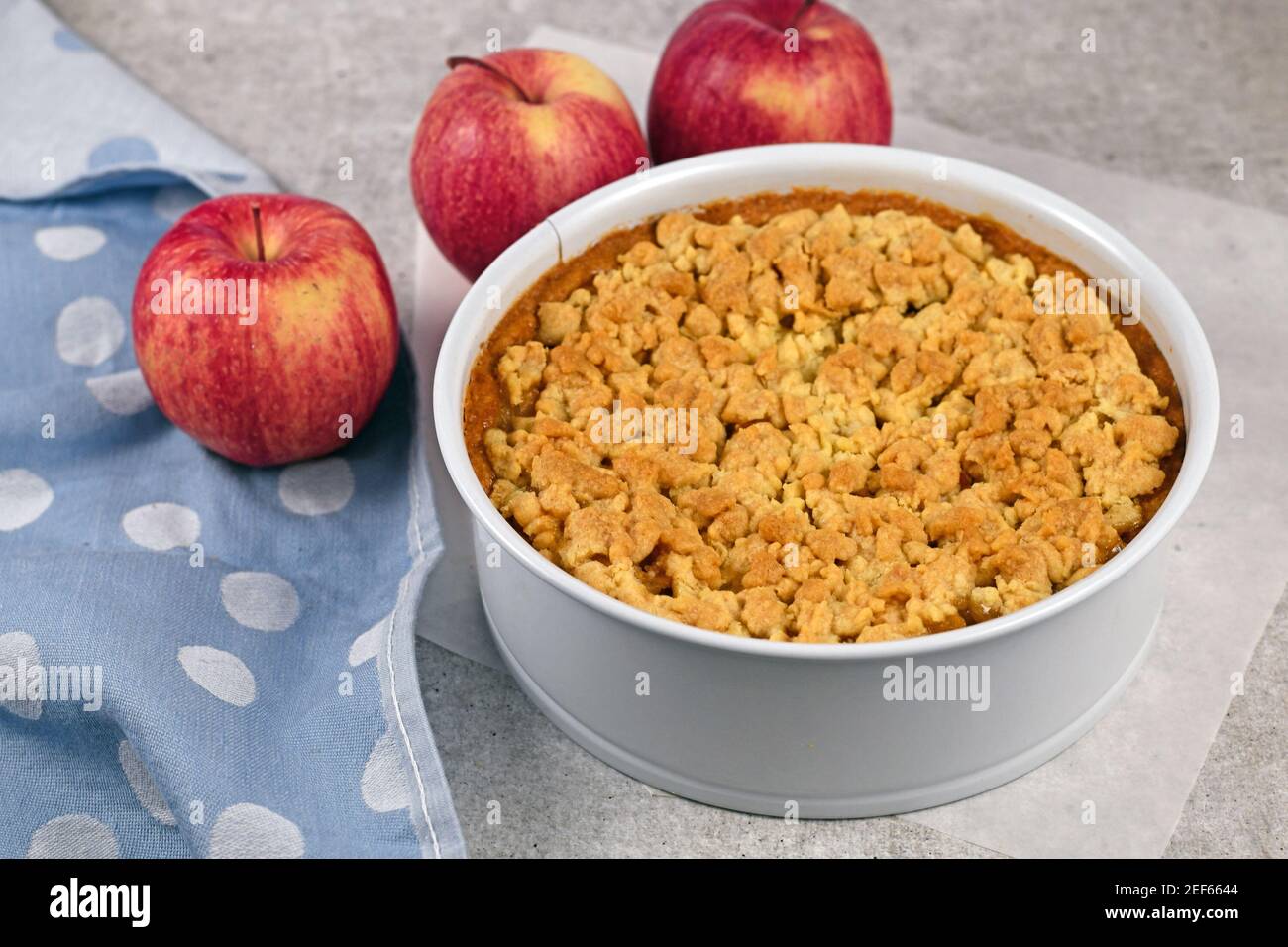 Whole traditional European apple pie with topping crumbles in white