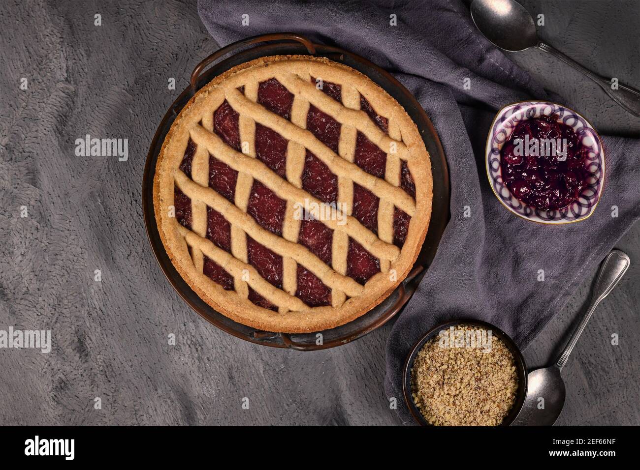 Top view of homemade pie called 'Linzer Torte', a traditional Austrian shortcake pastry topped with fruit preserves and sliced nuts with lattice desig Stock Photo