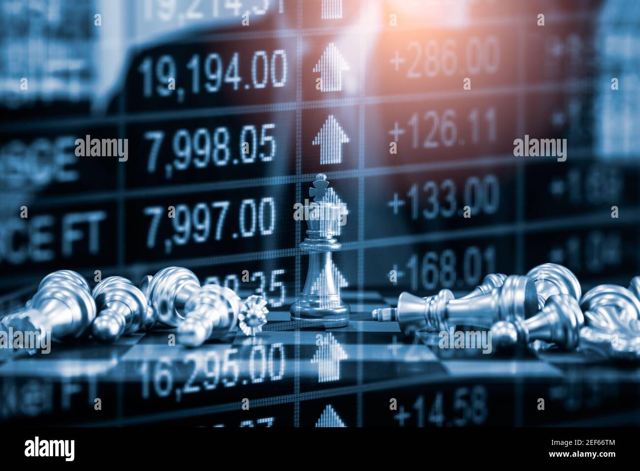 Chess game on chess board behind business man background. Business concept to present financial information and marketing strategy analysis. Investmen Stock Photo