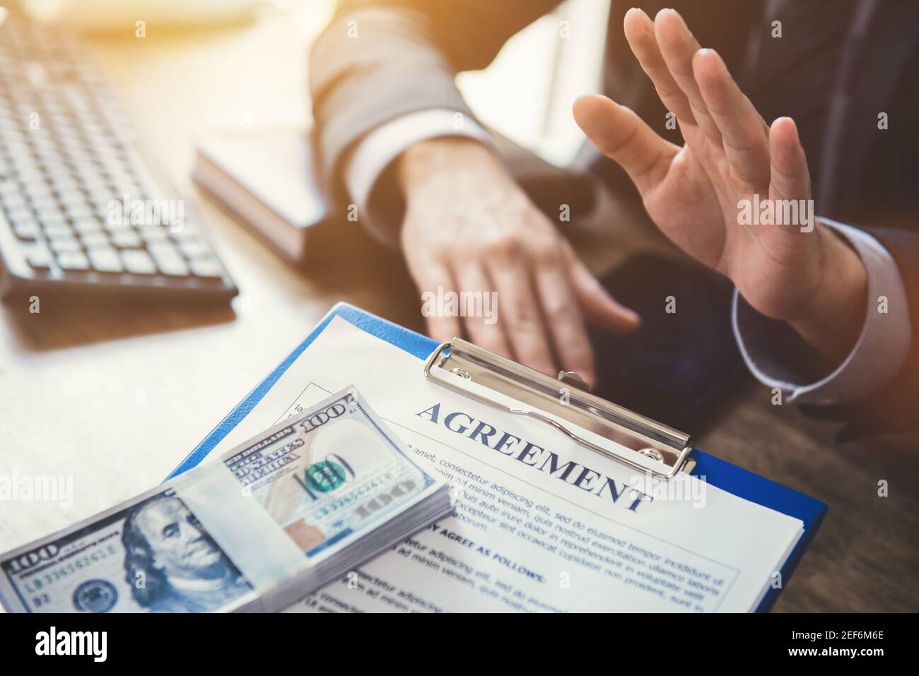 Businessman refusing money,US dollar bills, that come with agreement paper - anti bribery and corruption concepts Stock Photo