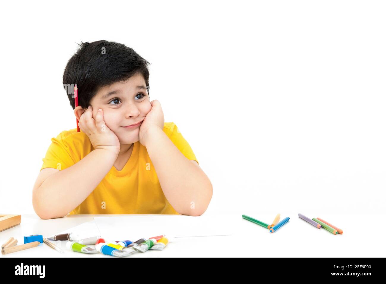 Cute little boy thinking of what to draw and paint - learning, education and imagination concepts Stock Photo