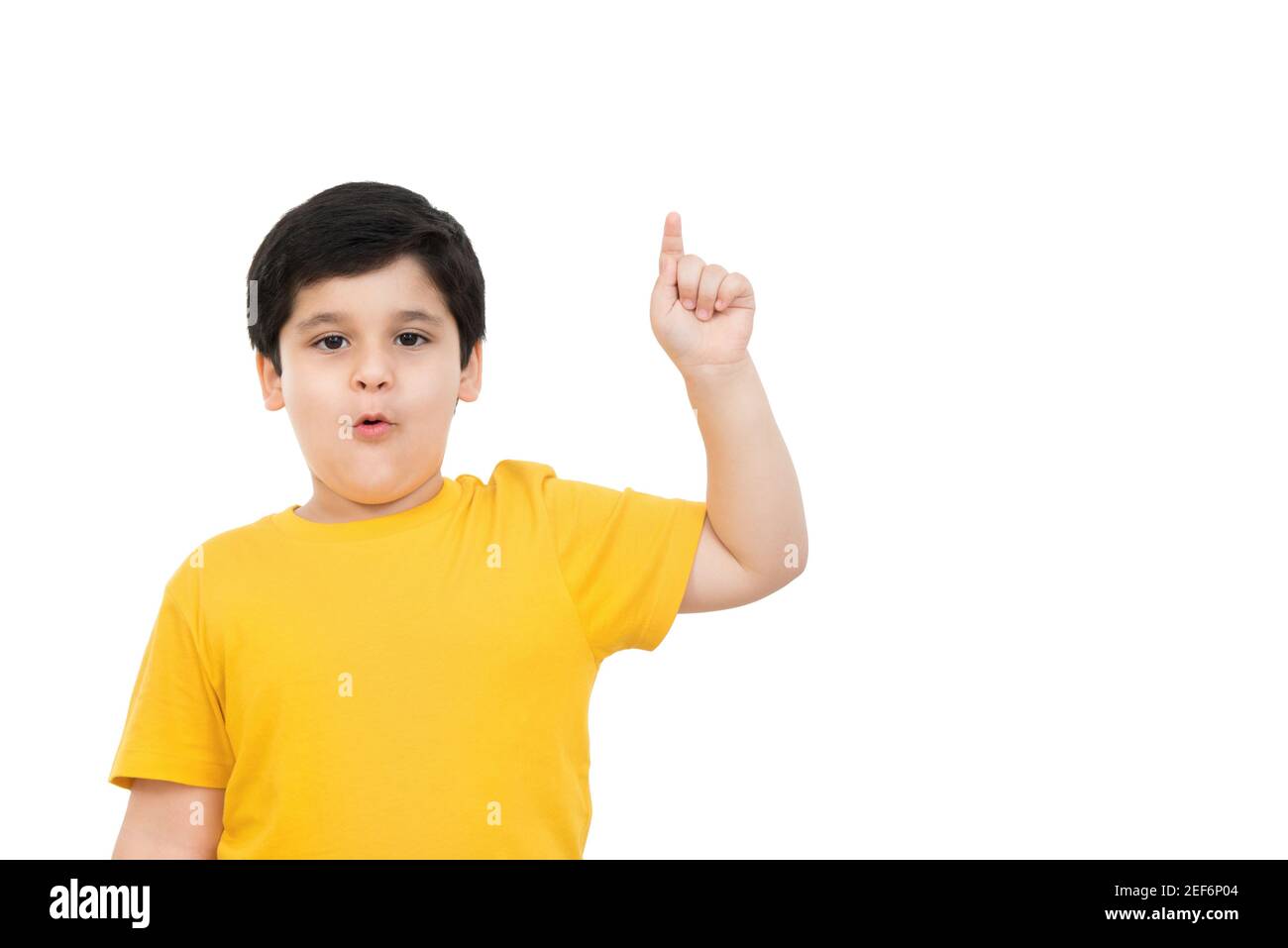 Young cute casual Asian boy pointing finger up with surprising face and mouth open ..oh - isolated on white background Stock Photo