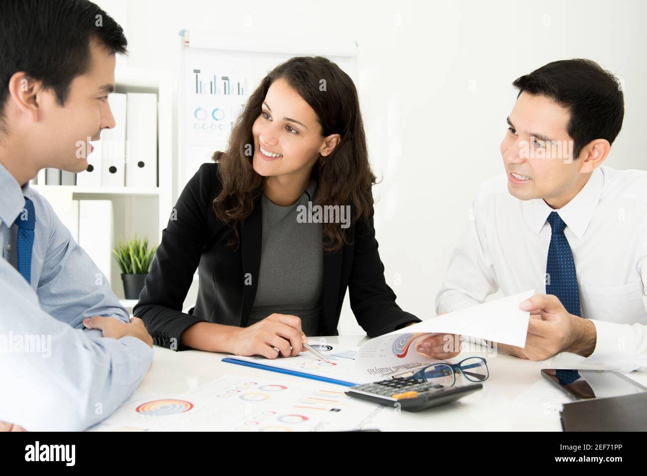 Group of multiethnic business people discussing financial documents at meeting table in the office Stock Photo