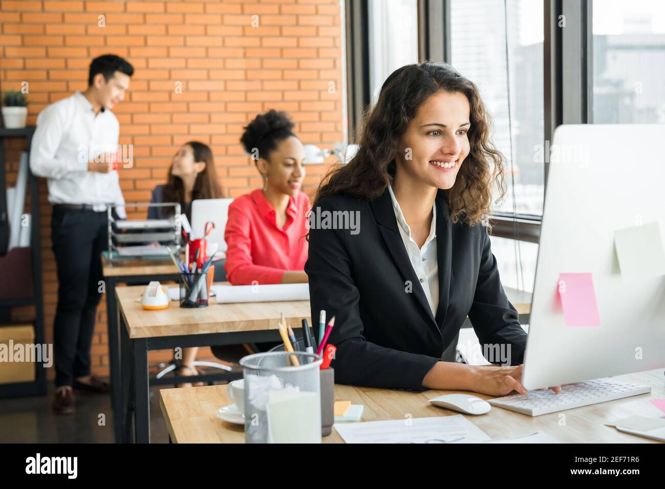 Businesswoman working in creative office with multiethnic colleagues Stock Photo
