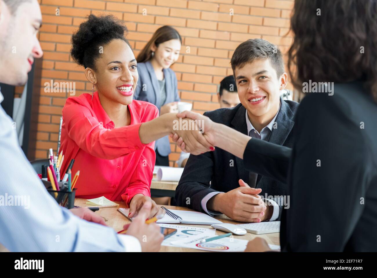 Caribbean businesswoman making handshake with her colleague in the meeting Stock Photo