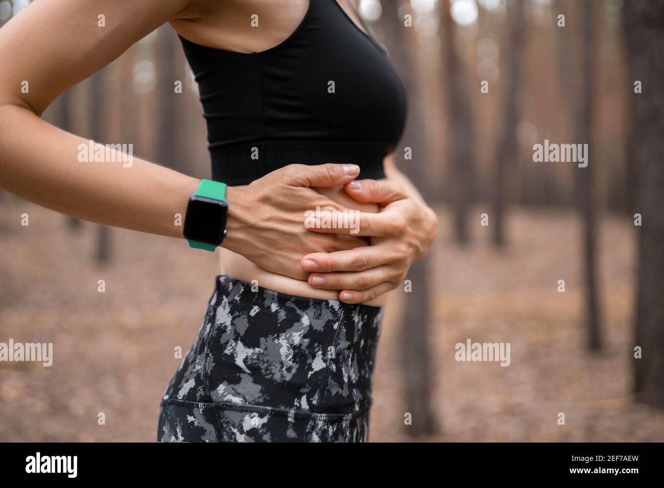 Side stitch woman runner side cramps after running. Jogging woman with