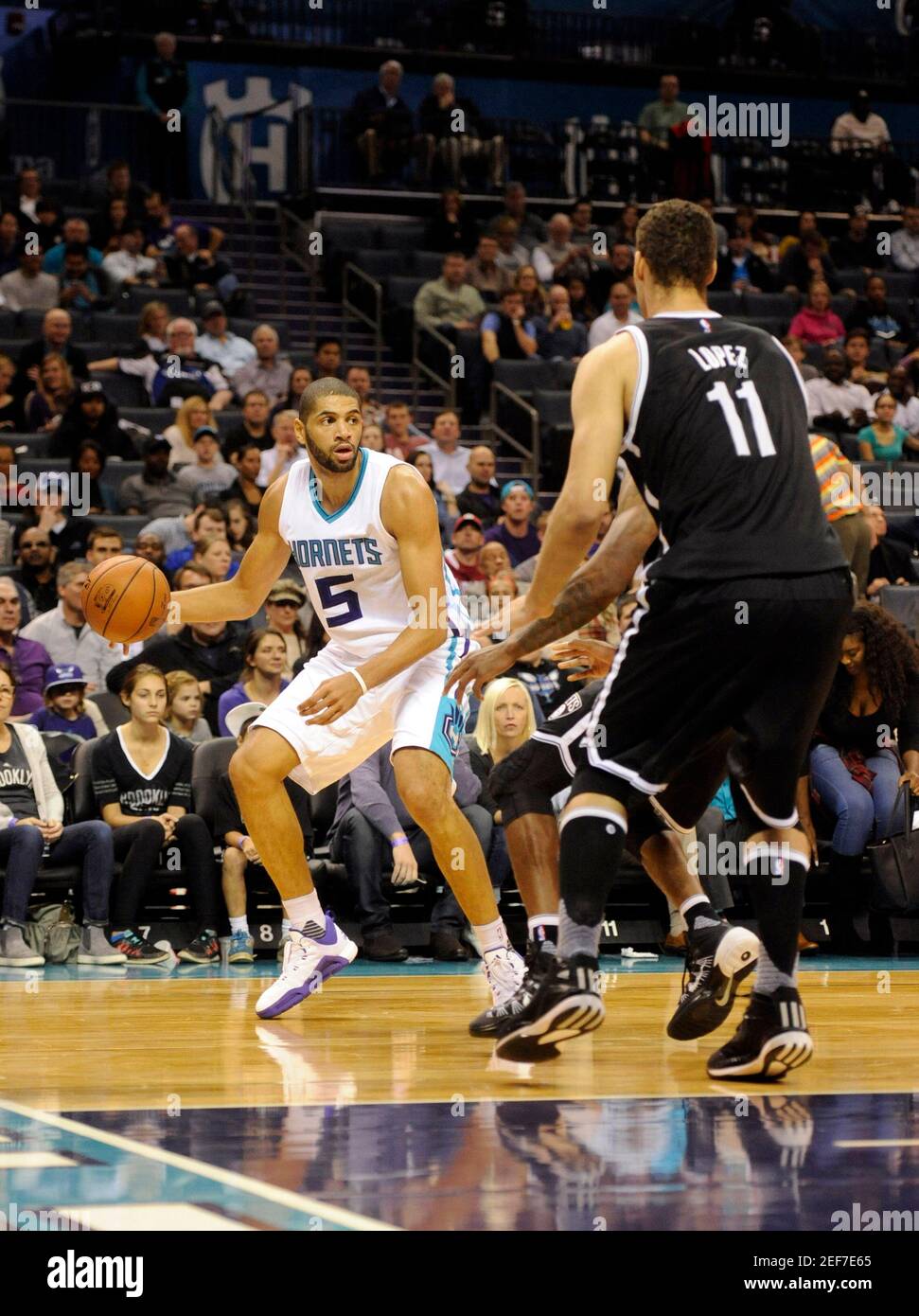 Nov 18, 2015; Charlotte, NC, USA; Charlotte Hornets guard forward Nicolas  Batum (5) prepares to pass the ball as he is guarded by Brooklyn Nets  center Brook Lopez (11) during the first
