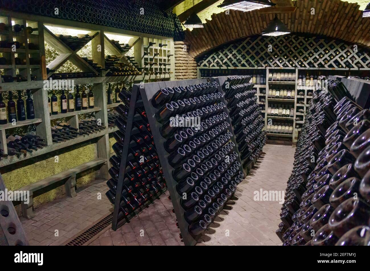 Wine cellar. The bottles on wooden shelves. Vintage storage of wine
