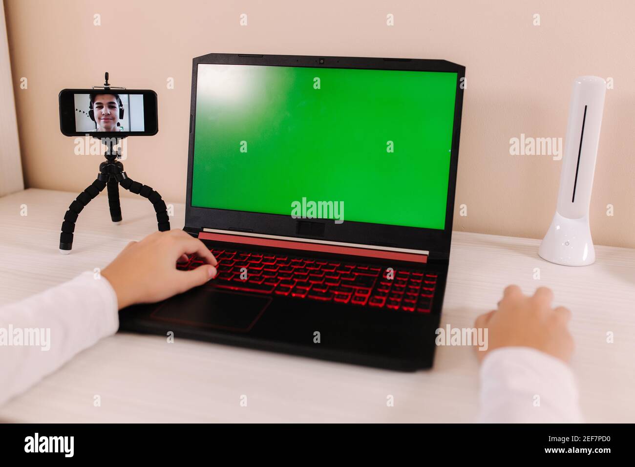 First person view of boy playing games on laptop at home. Green screen ...