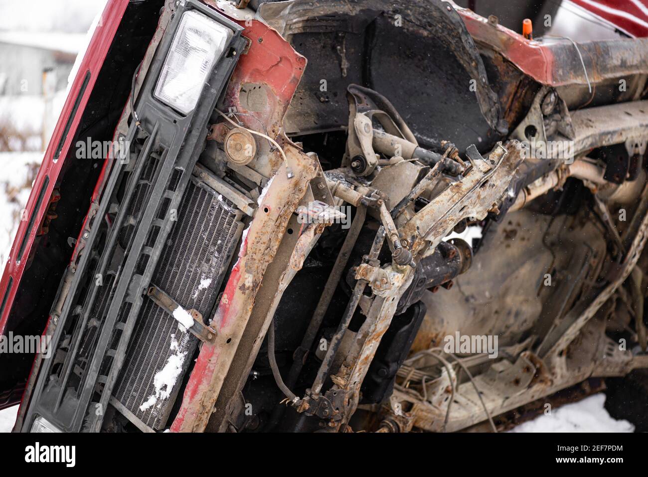 Old rusted torched broken-down red car without wheels winter day snowflakes Stock Photo