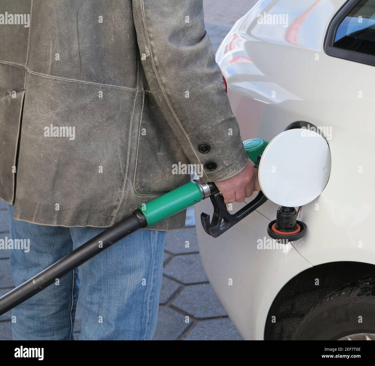 Close up of male hand topping up car tank with unleaded gasoline Stock Photo