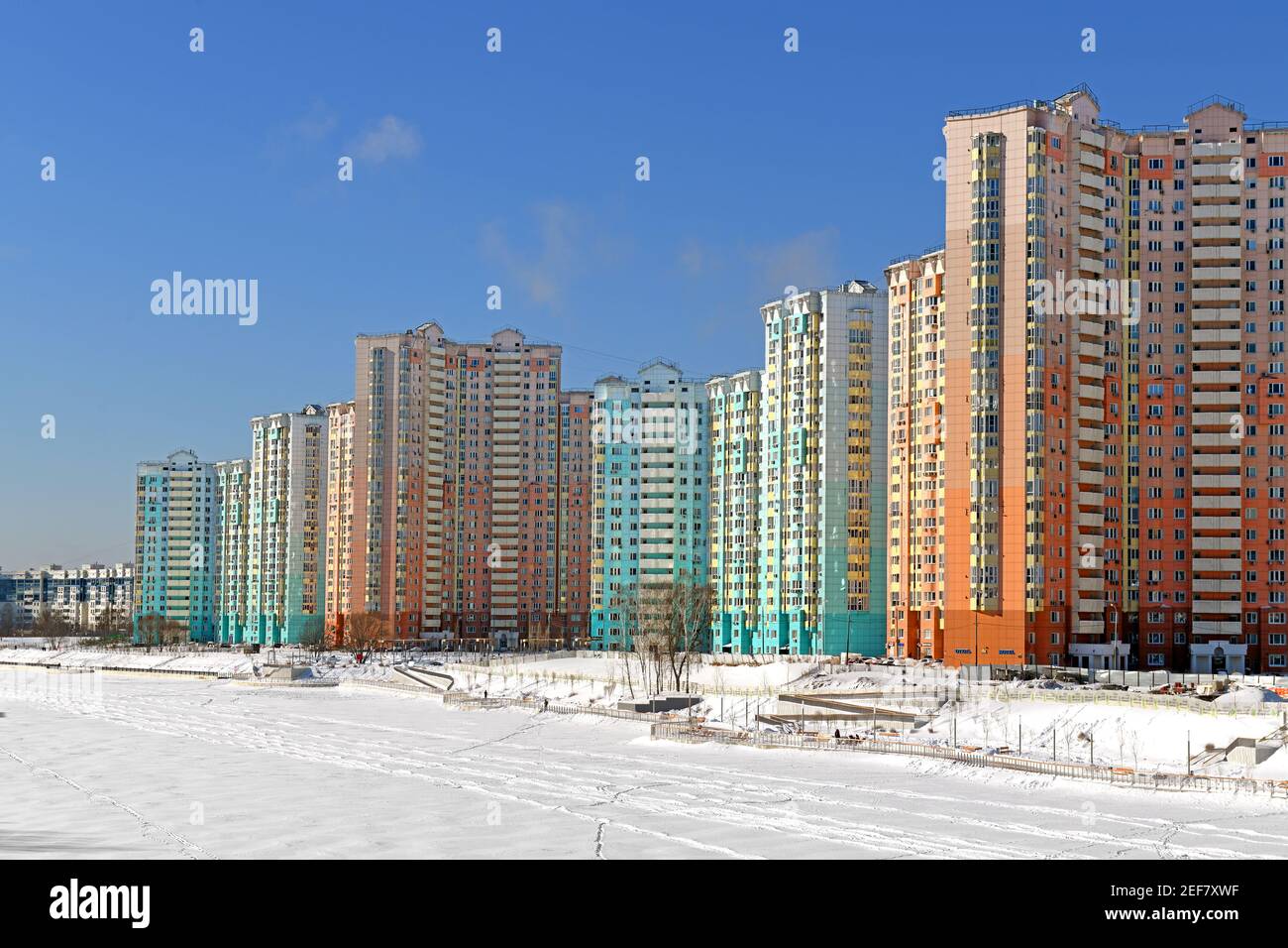 New buildings on snow-covered embankment of Moskva river on background of blue sky. Winter landscape Stock Photo
