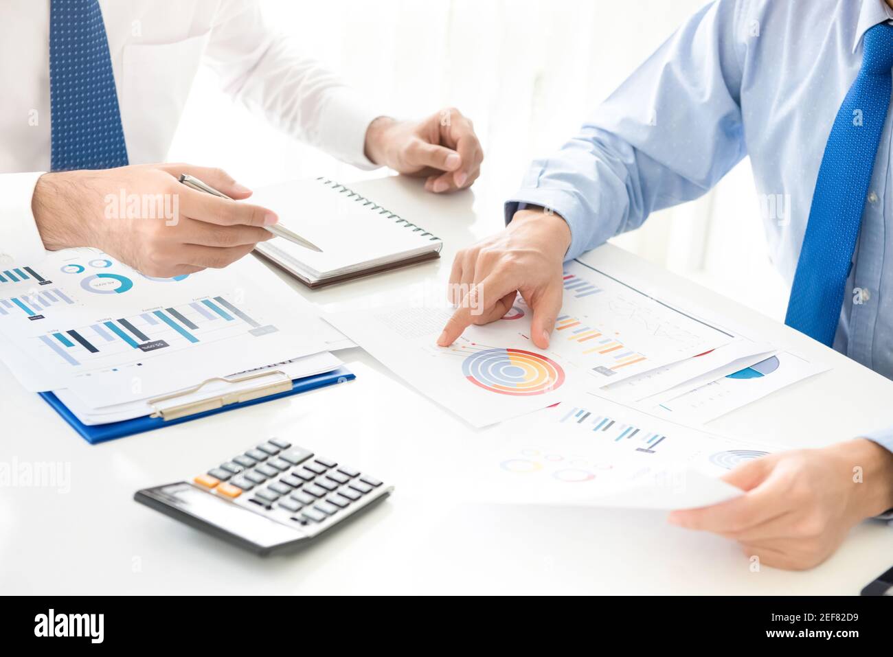 Businessmen discussing and analyzing financial documents Stock Photo