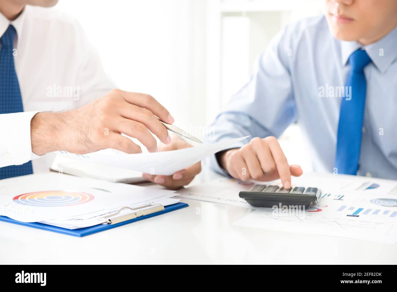 Businessmen discussing and analyzing financial documents Stock Photo