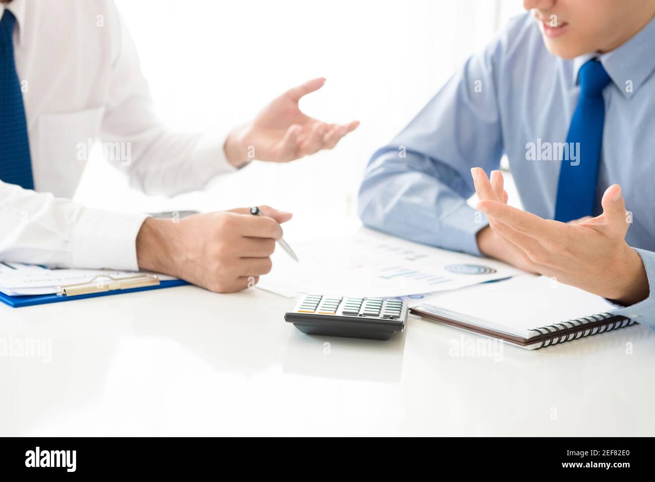 Businessmen discussing and analyzing financial documents Stock Photo
