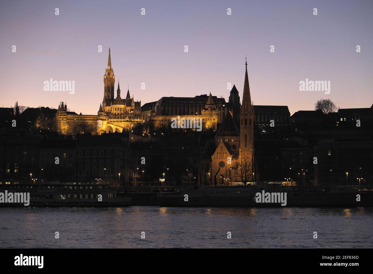 St Matthias Church and Fisherman's Bastion, with (I think) Szilagyi Dezso Church below, seen over River Duna (Danube) at night, Budapest, Hungary. Stock Photo