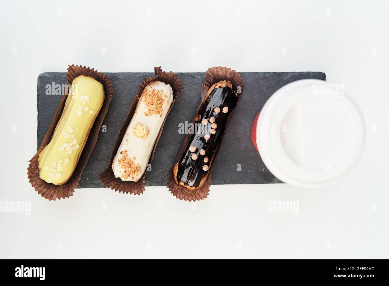 Three eclairs on a black tray top view Stock Photo