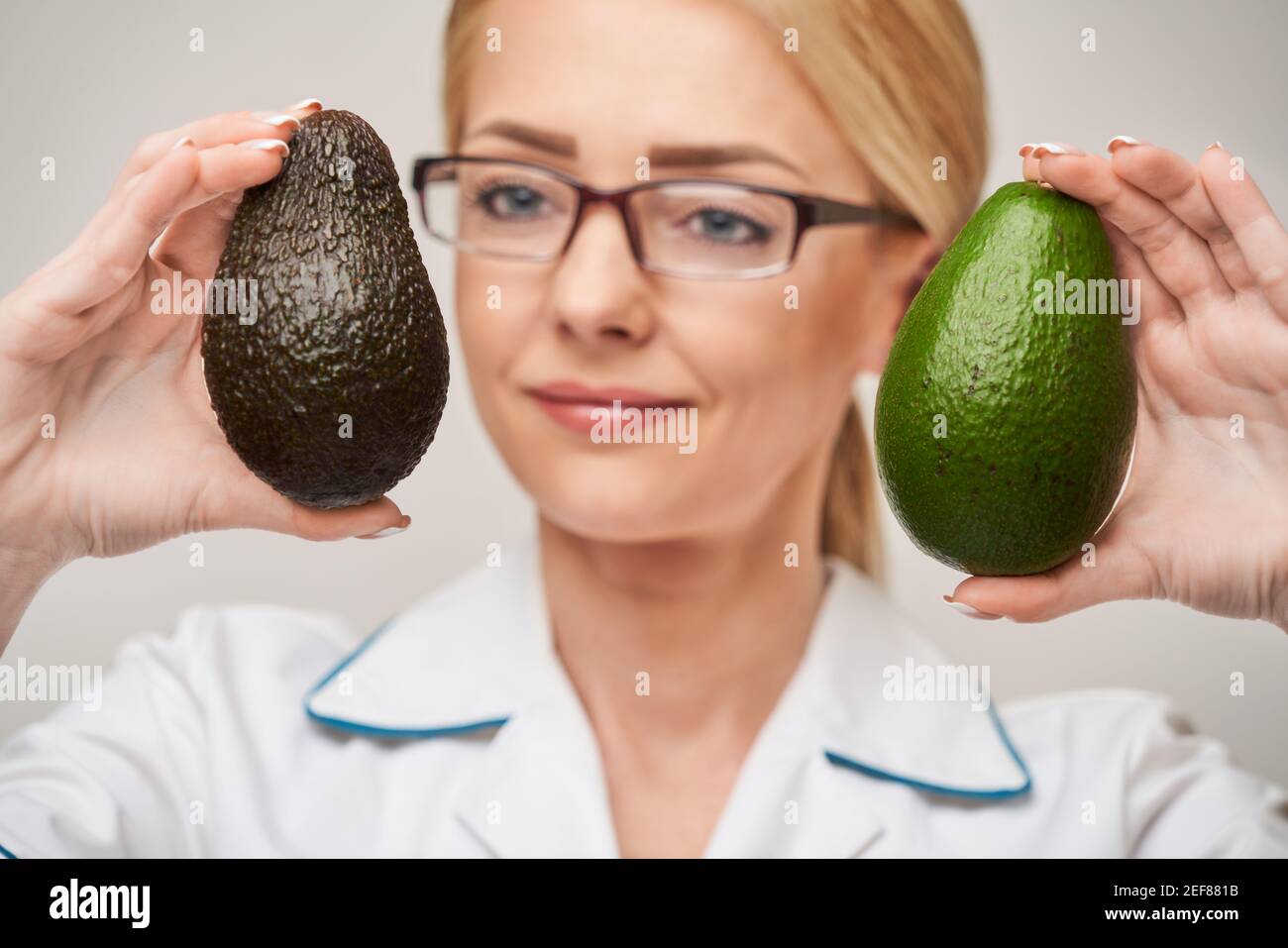 nutritionist doctor healthy lifestyle concept holding organic avocado