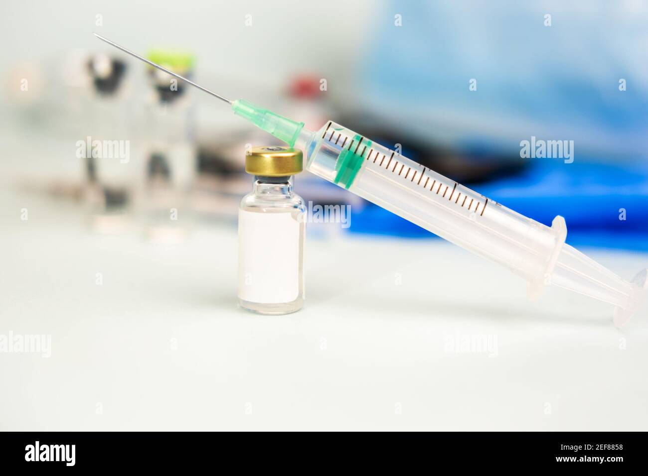 Syringe with ampoule of medicine on blurred medical background. treatment, prevention, laboratory, infection. soft focus. copy space, mock up. coronav Stock Photo