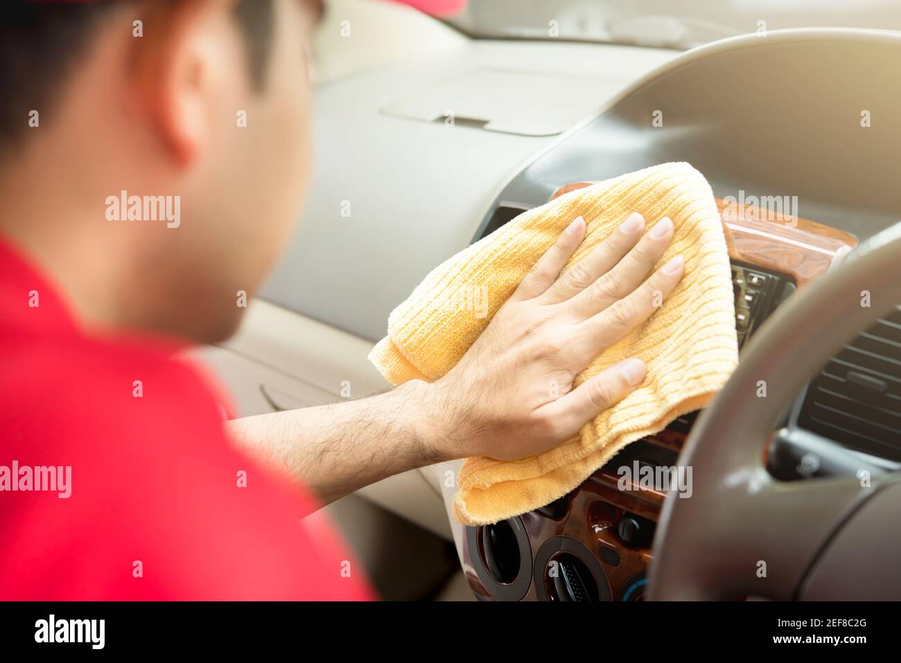 A man cleaning car interior with microfiber cloth auto detailing and valeting concept Stock