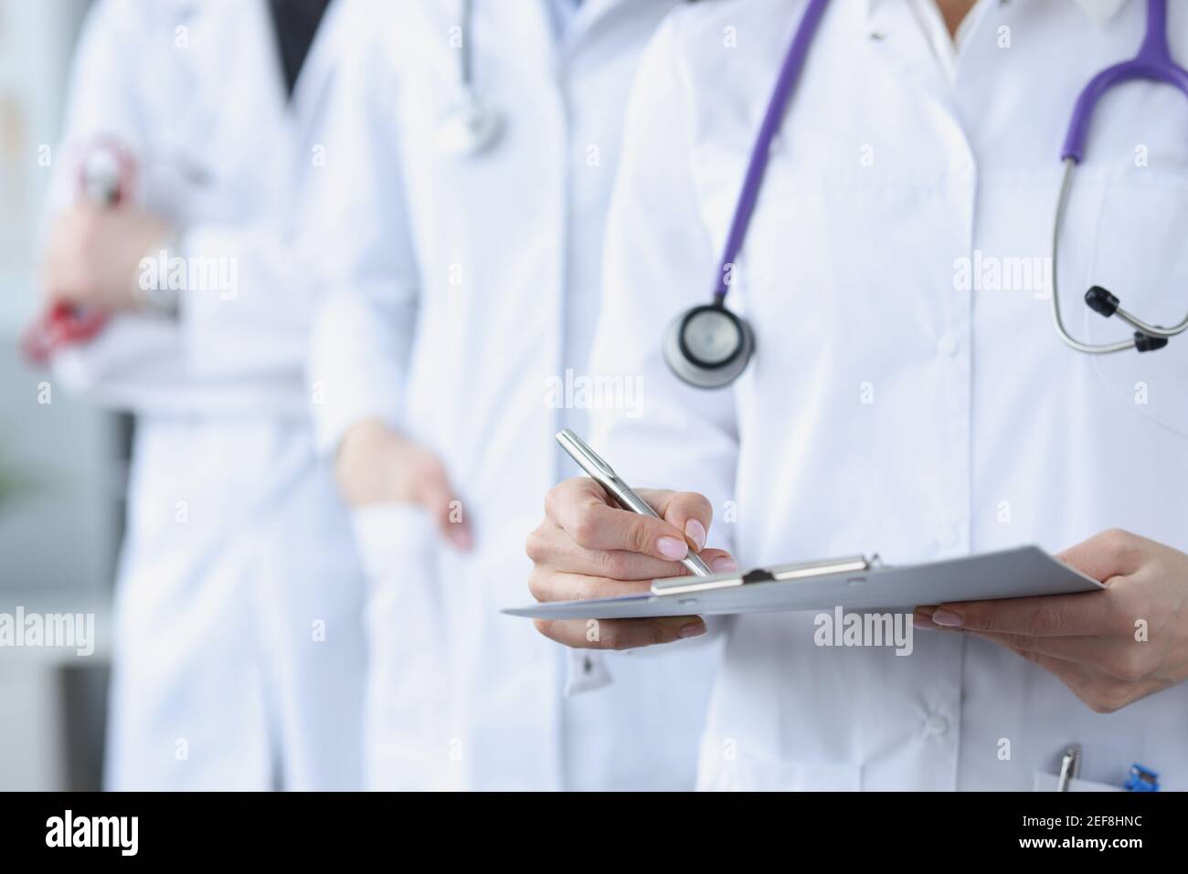 Doctors in white medical coats stand together Stock Photo