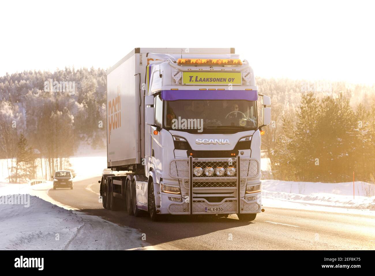 Beautifully customized Scania S of T Laaksonen Oy for Posti Finnish Postal deliveries on a bright sunny day in winter. Salo, Finland. Feb 11, 2021. Stock Photo
