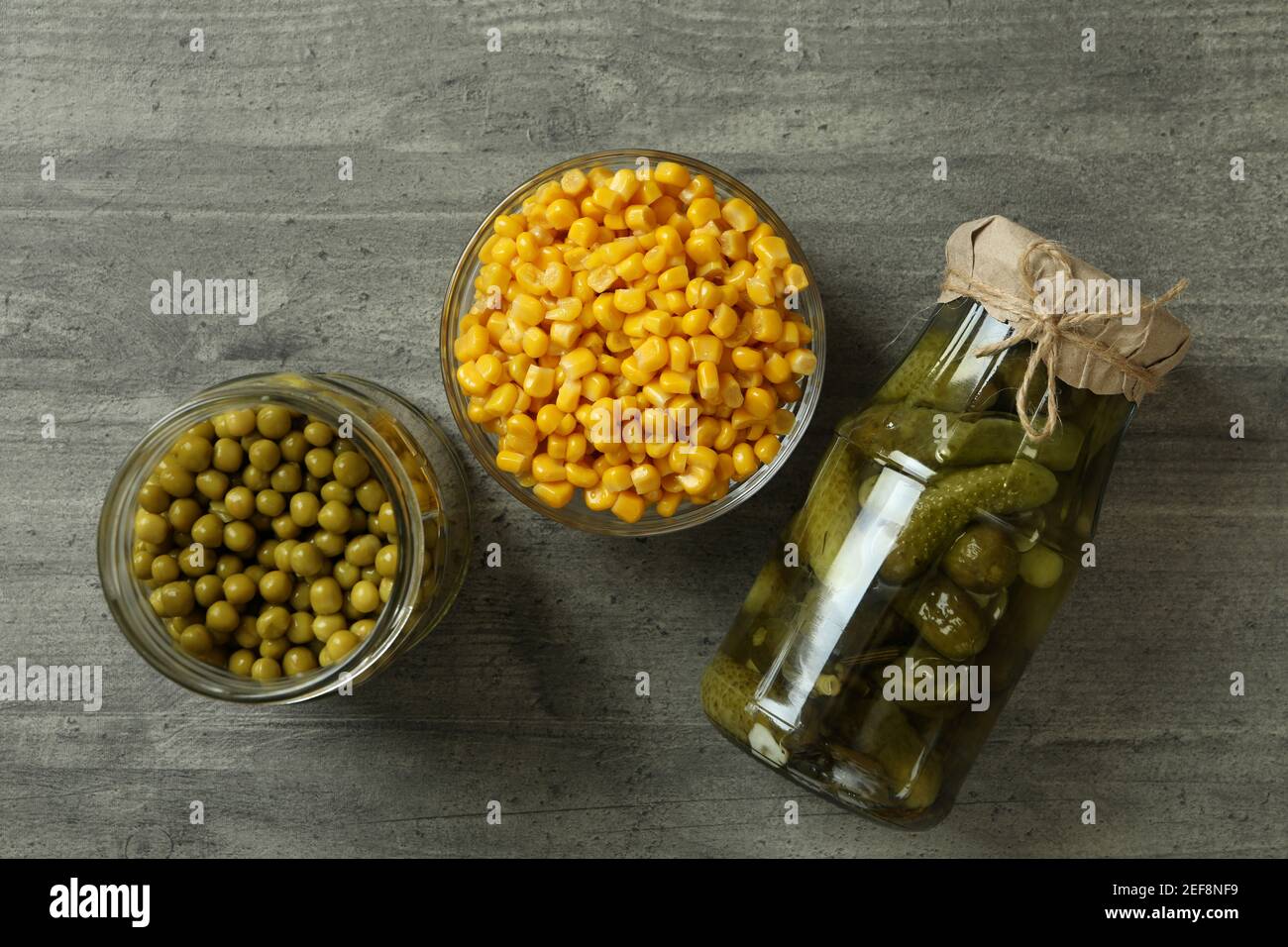 Pickled cucumbers, corn and peas on gray background Stock Photo