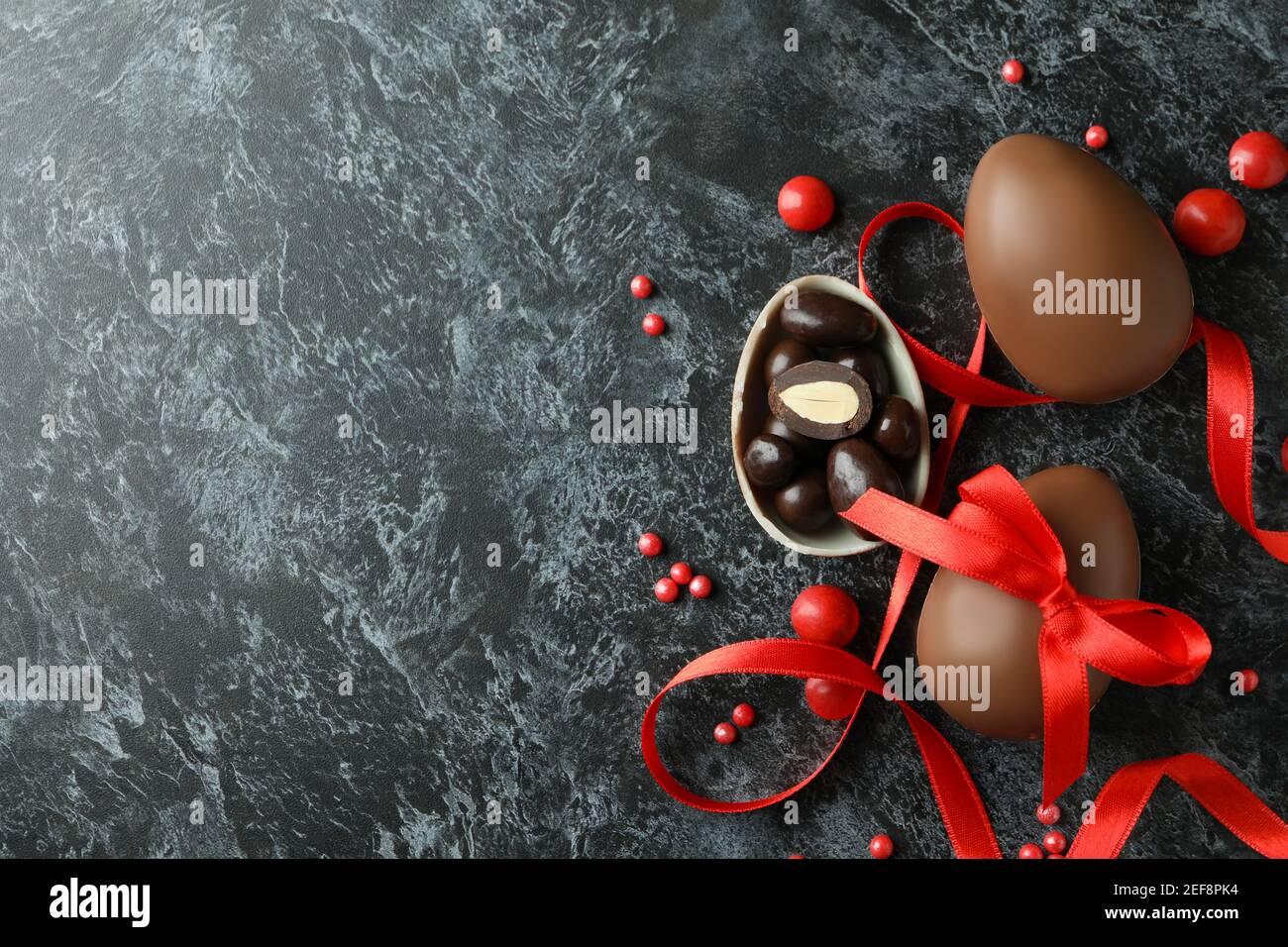Easter chocolate eggs with candies on black smokey background Stock ...