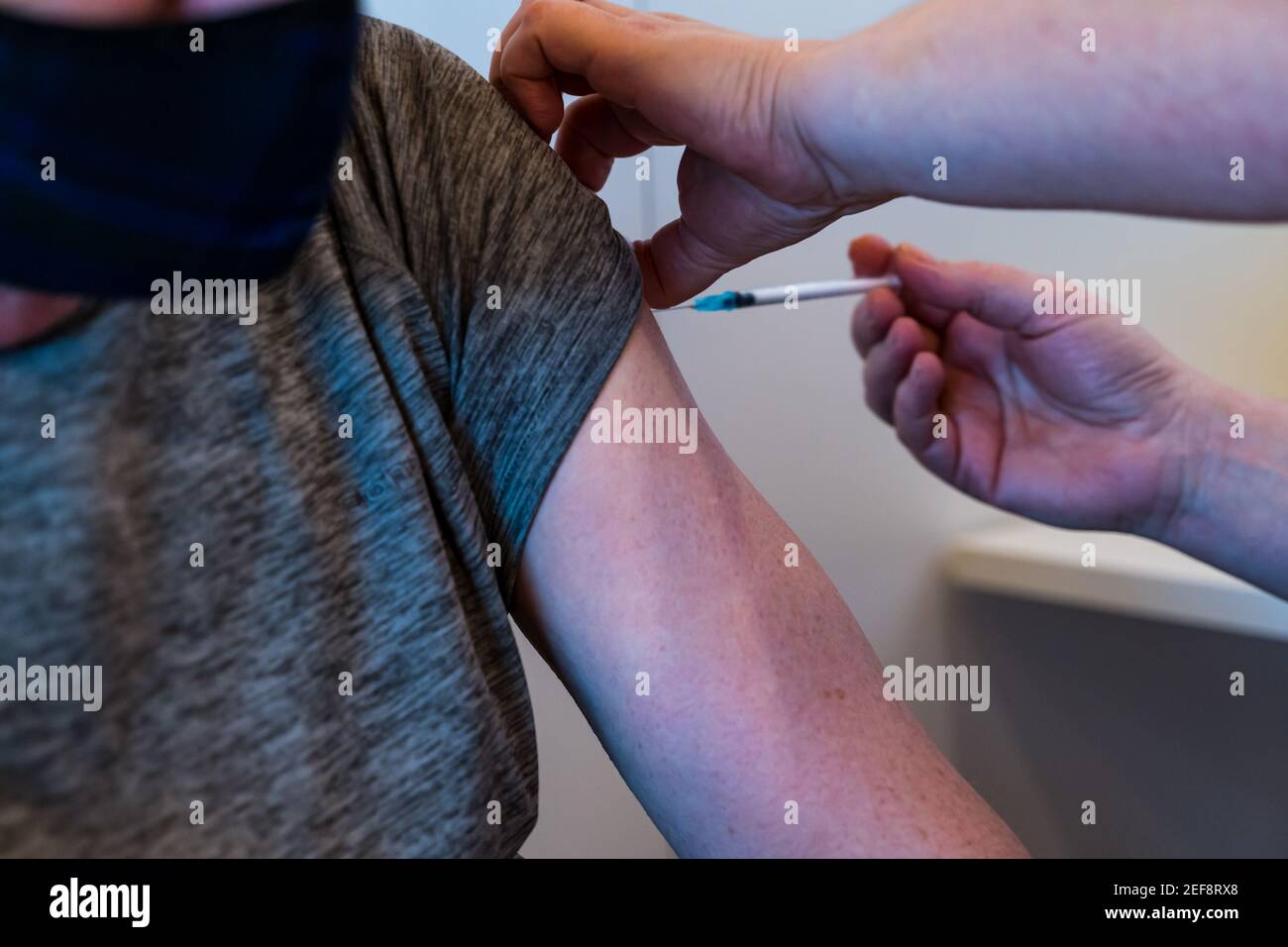 Edinburgh, Scotland, United Kingdom, 17th February 2021. Covid-19 vaccination centre at Ingliston: the vaccination programme for the over 60s in Scotland continues at Royal Highland Showground, Ingliston. A 68 year old man has his first Pfizer vaccination from a nurse Stock Photo