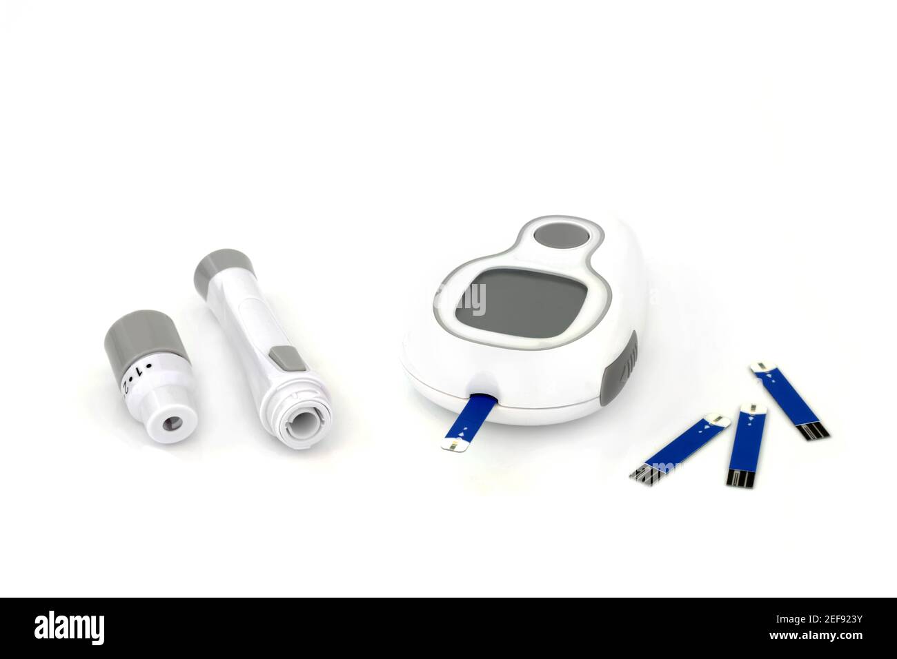 Diabetes monitoring and testing equipment kit with blood glucose monitor meter, lancing device & tester strip. On white background. Stock Photo