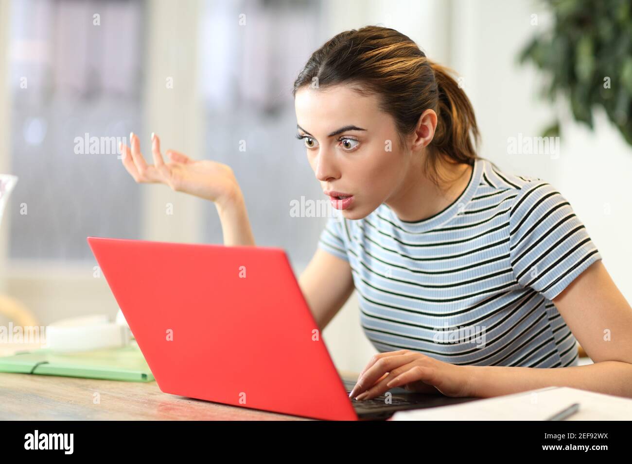 Stunned student watching laptop content complaining at home Stock Photo