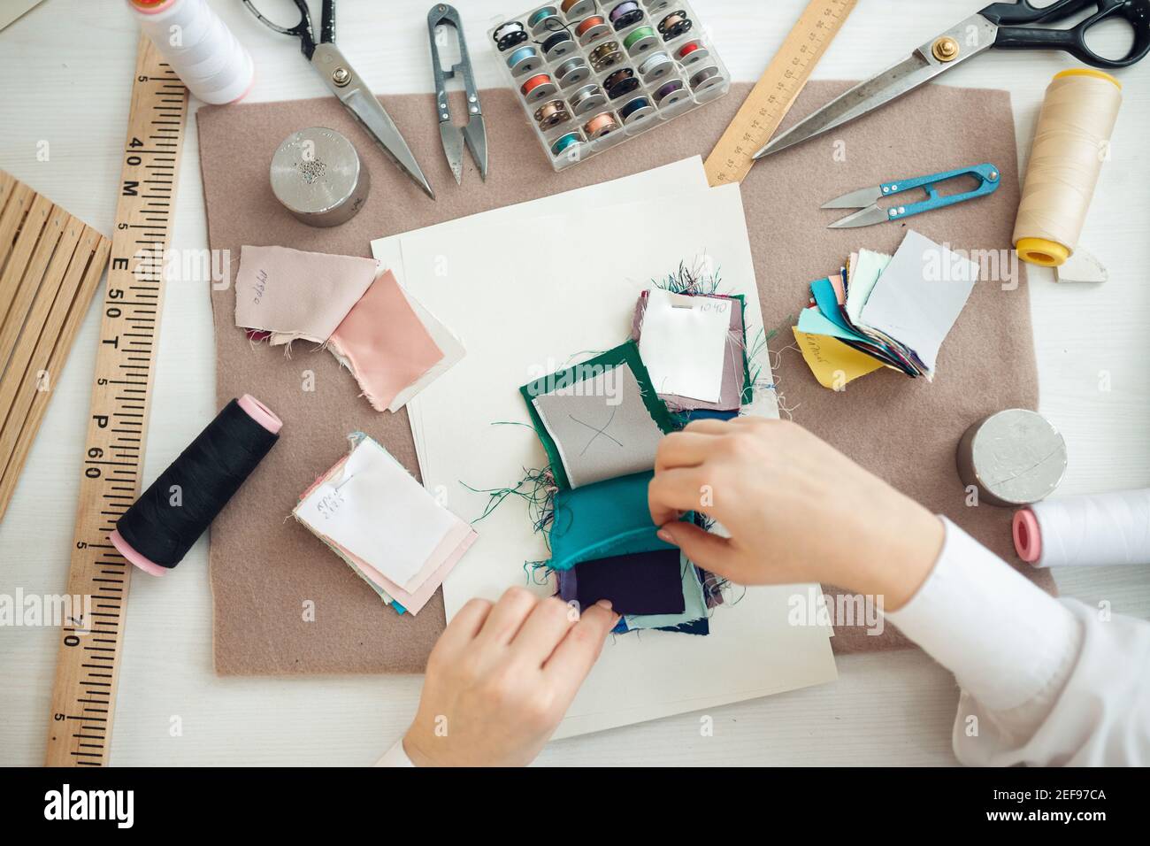 the seamstress chooses a sample of fabric for sewing clothes Stock