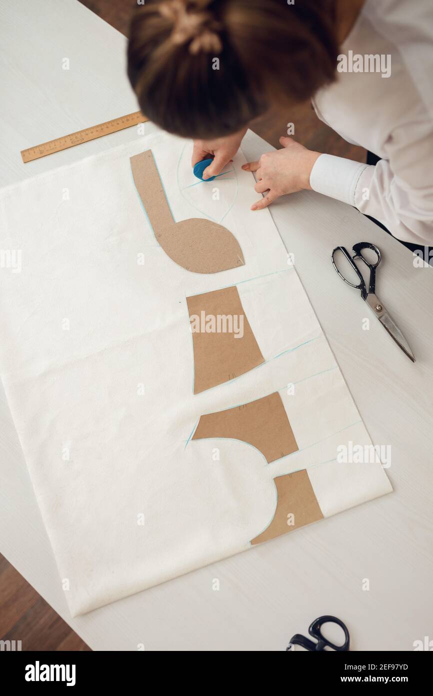 Close up. hands woman Tailor working cutting a roll of fabric on which