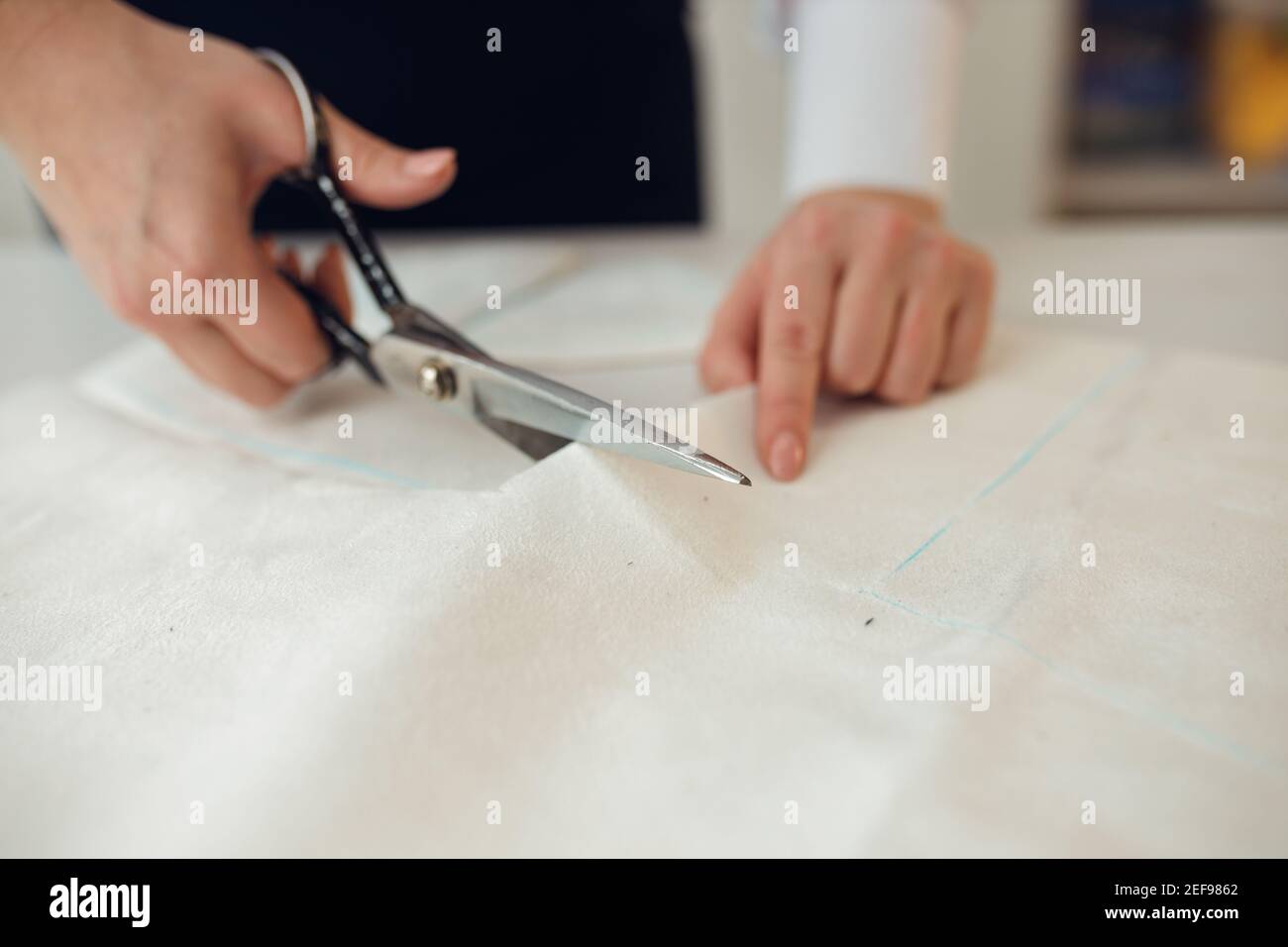 Close up. hands woman Tailor working cutting a roll of fabric on which