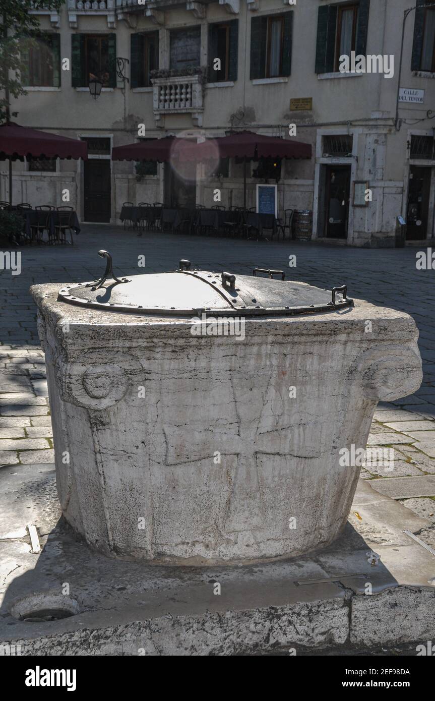 Typical venetian cisternae near calle del tentor, Venice Italy. Stone Cistern with iron Cover. Stock Photo
