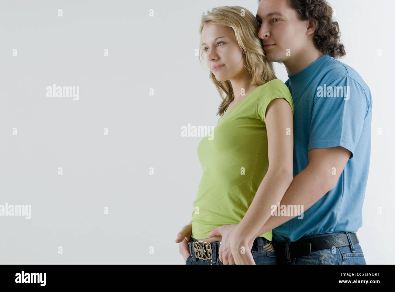 Side profile of a young man embracing a young woman from behind Stock ...