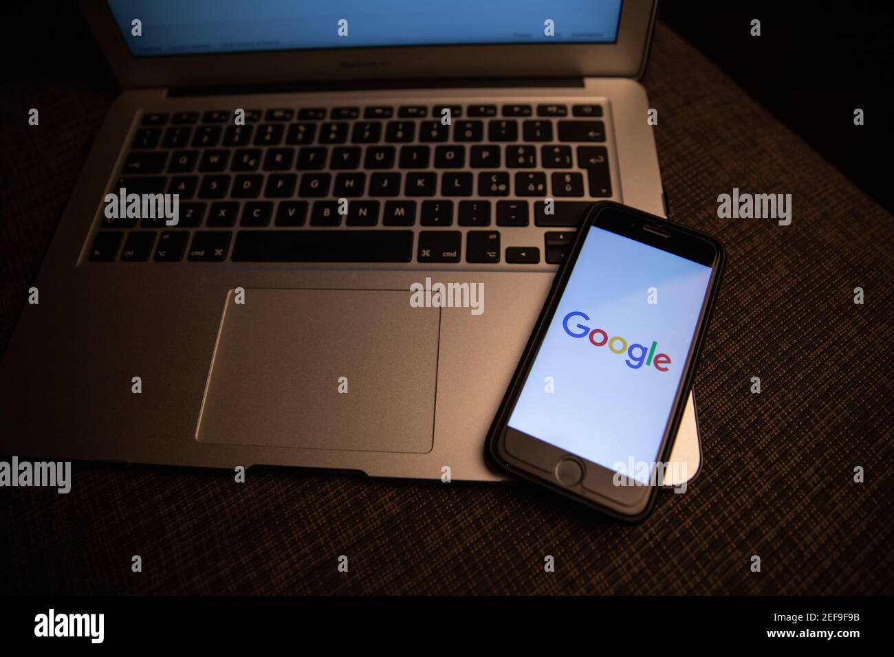 Smartphone with Google logo resting on a laptop's keyboard. Google is the most used search engine on the World Wide Web. Stock Photo