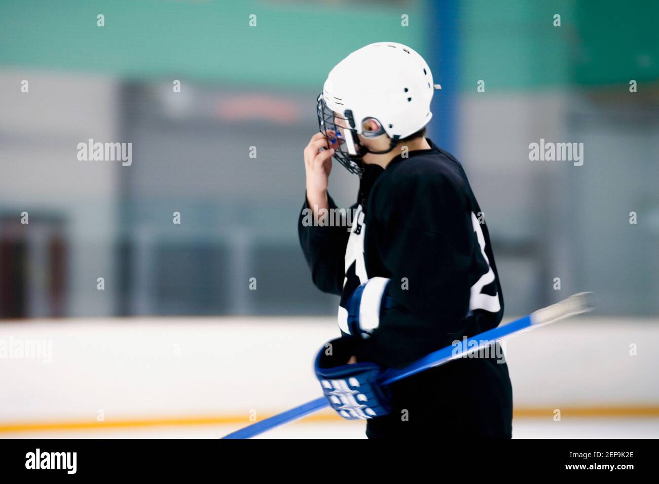 Side profile of an ice hockey player holding an ice hockey stick Stock Photo