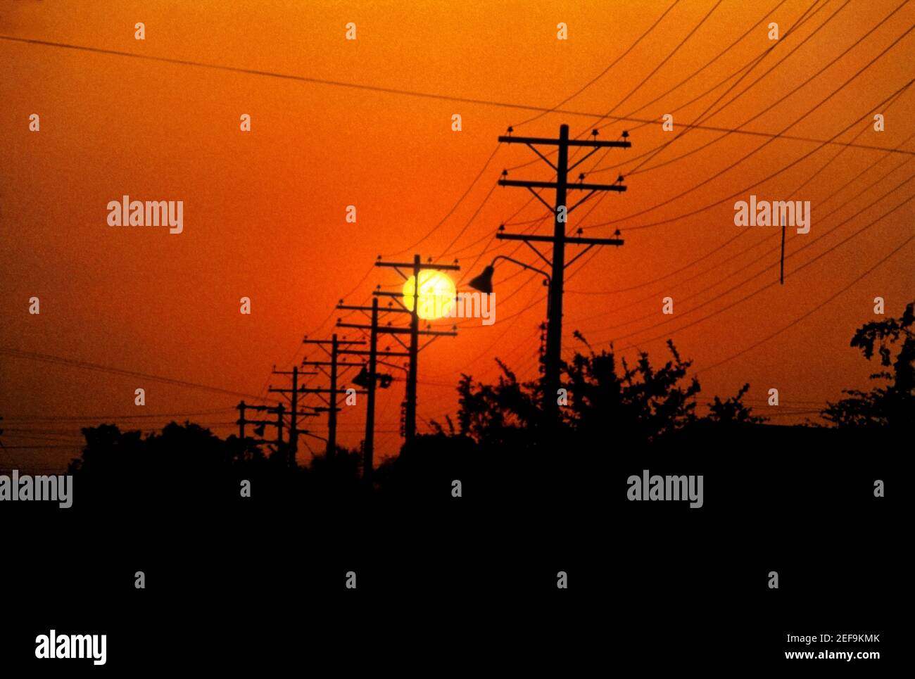 Silhouette of electricity pylons and power lines at sunset Stock Photo ...