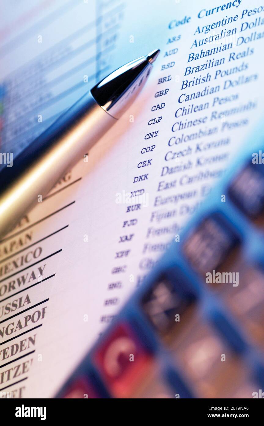 Pen in front of list of world currencies with codes for each country