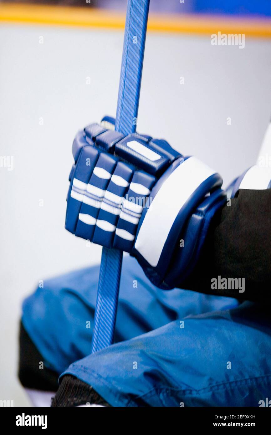 Mid section view of an ice hockey player holding an ice hockey stick