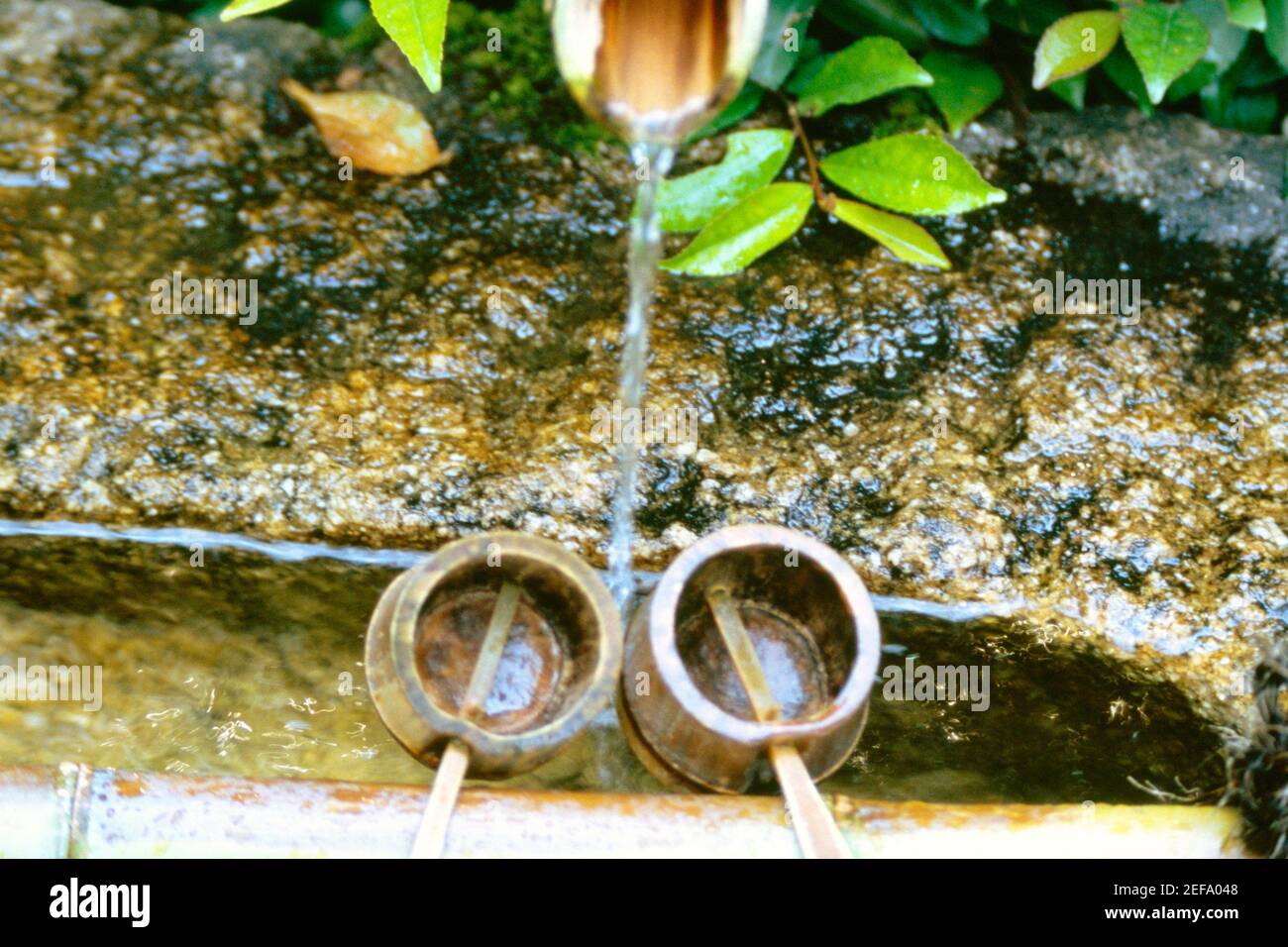 High angle view of water flowing from a pipe into the buckets, Ryoanji Temple, Kyoto, Japan Stock Photo