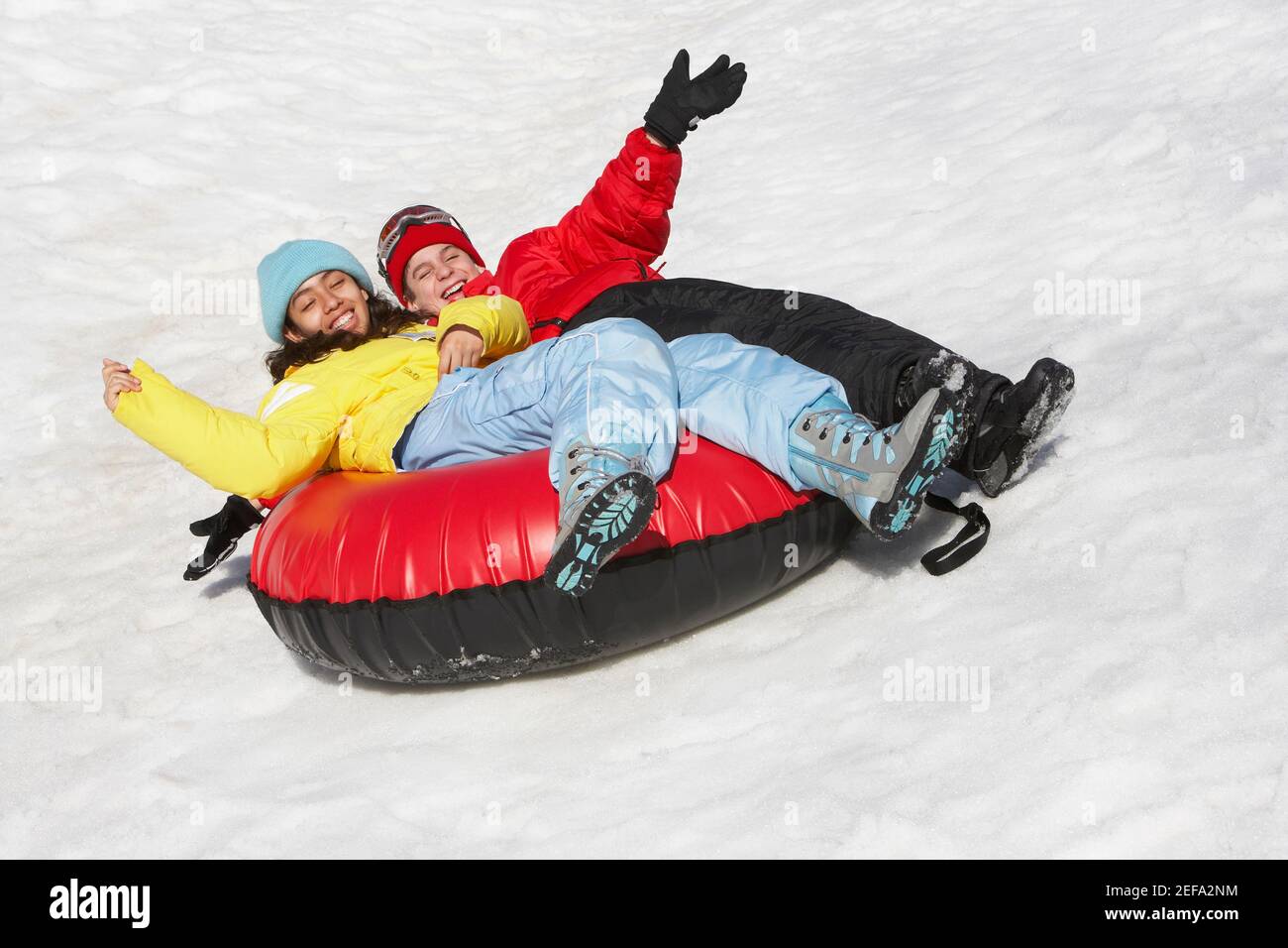 Boy and a girl sliding with an inner tube in snow Stock Photo Alamy