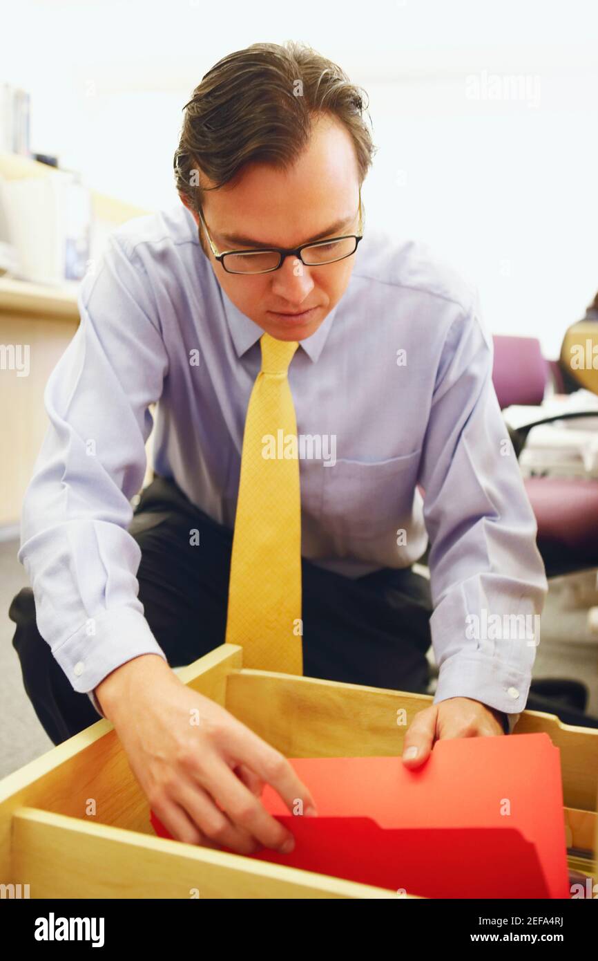 Close-up of a businessman looking into a file in a drawer Stock Photo