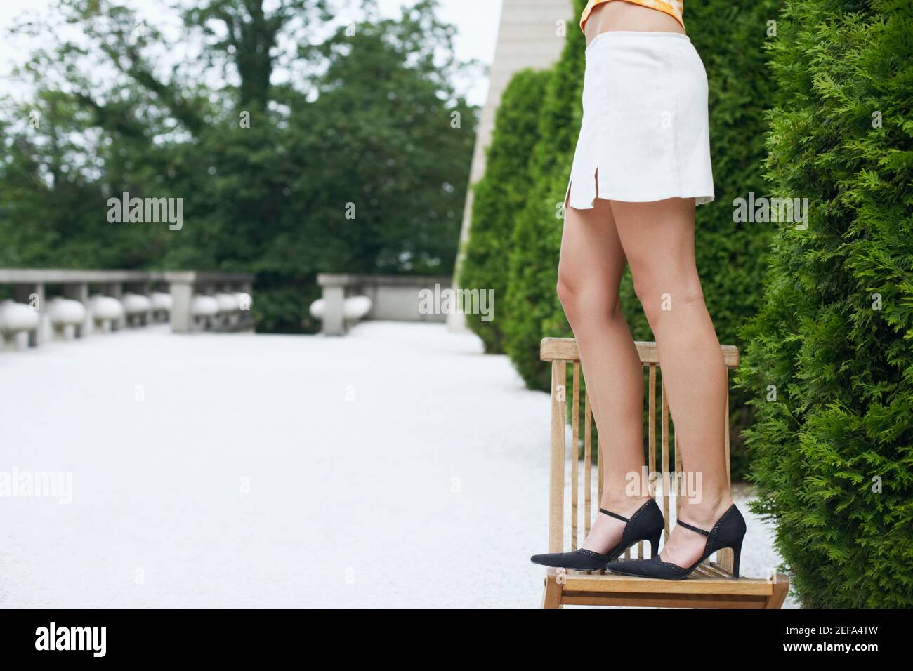 Low section view of a young woman standing on a chair Stock Photo