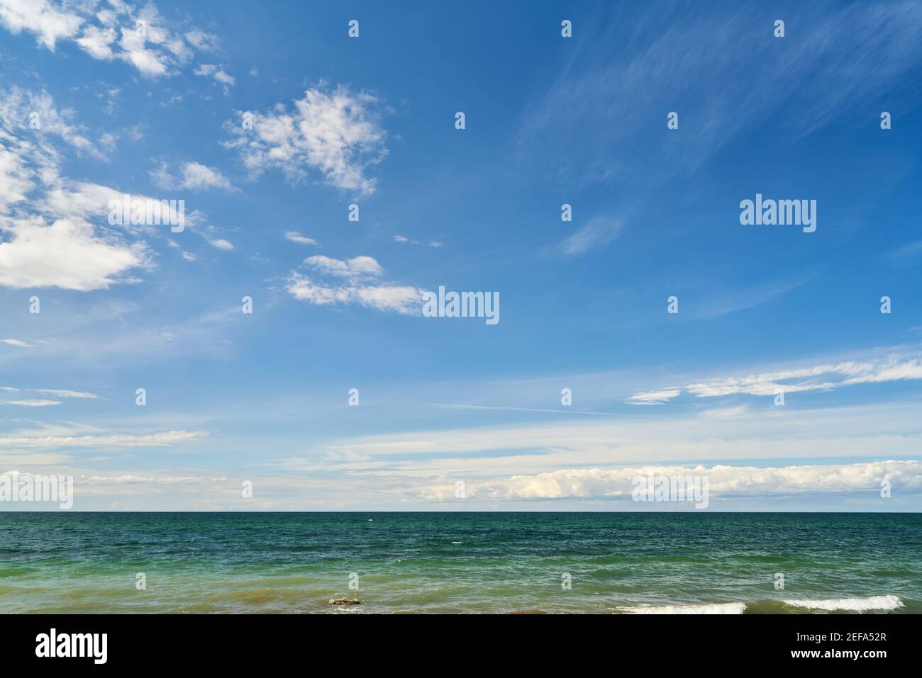 Blue sky and white clouds over waves from the ocean in the day Stock ...