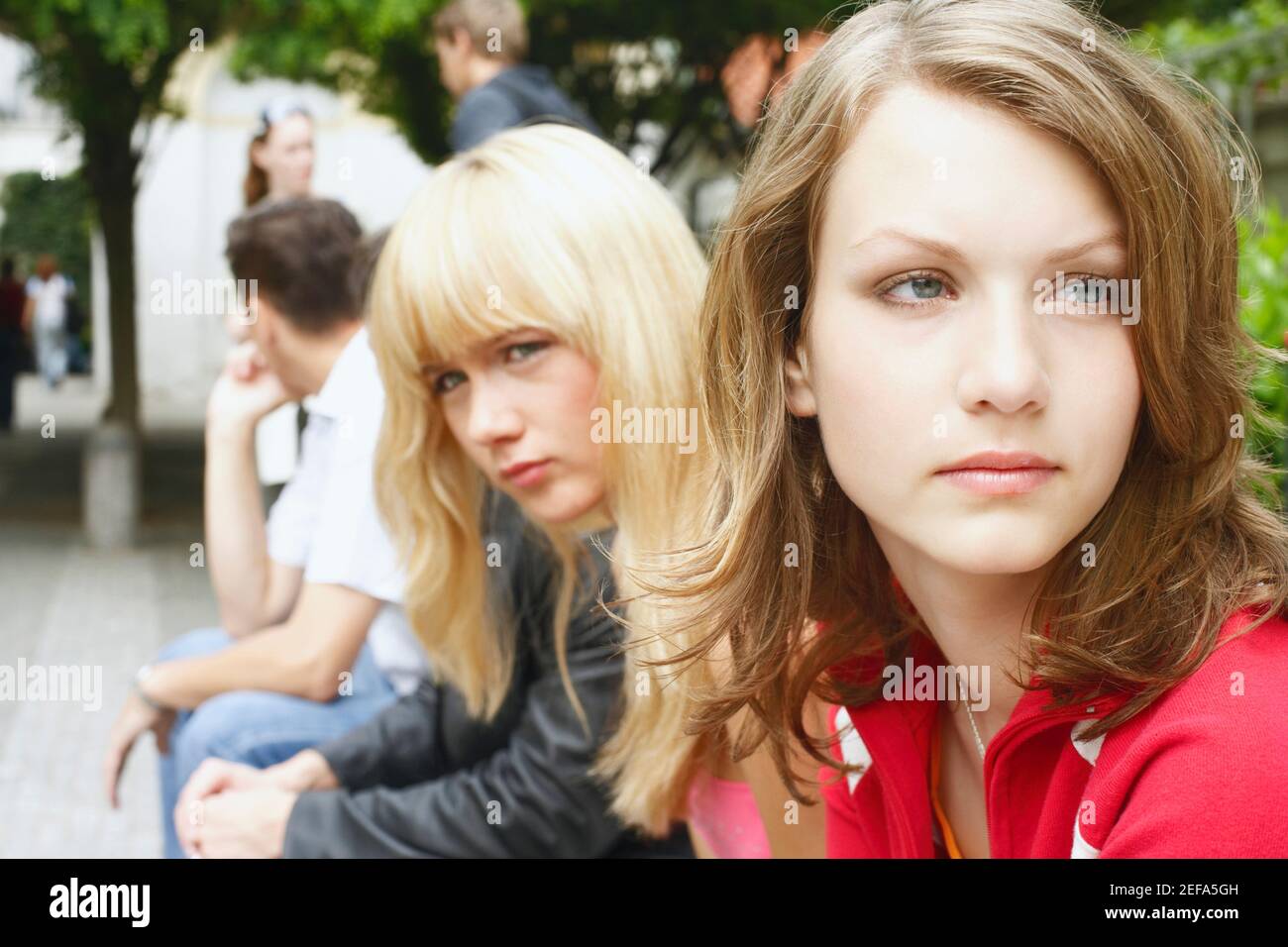 Side profile of a young woman and a teenage girl sitting Stock Photo