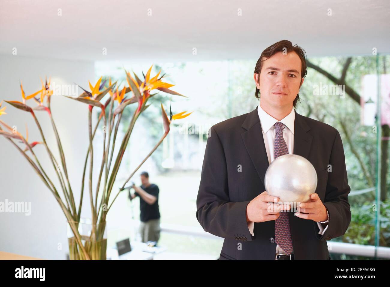 Portrait of a businessman holding a crystal ball Stock Photo - Alamy