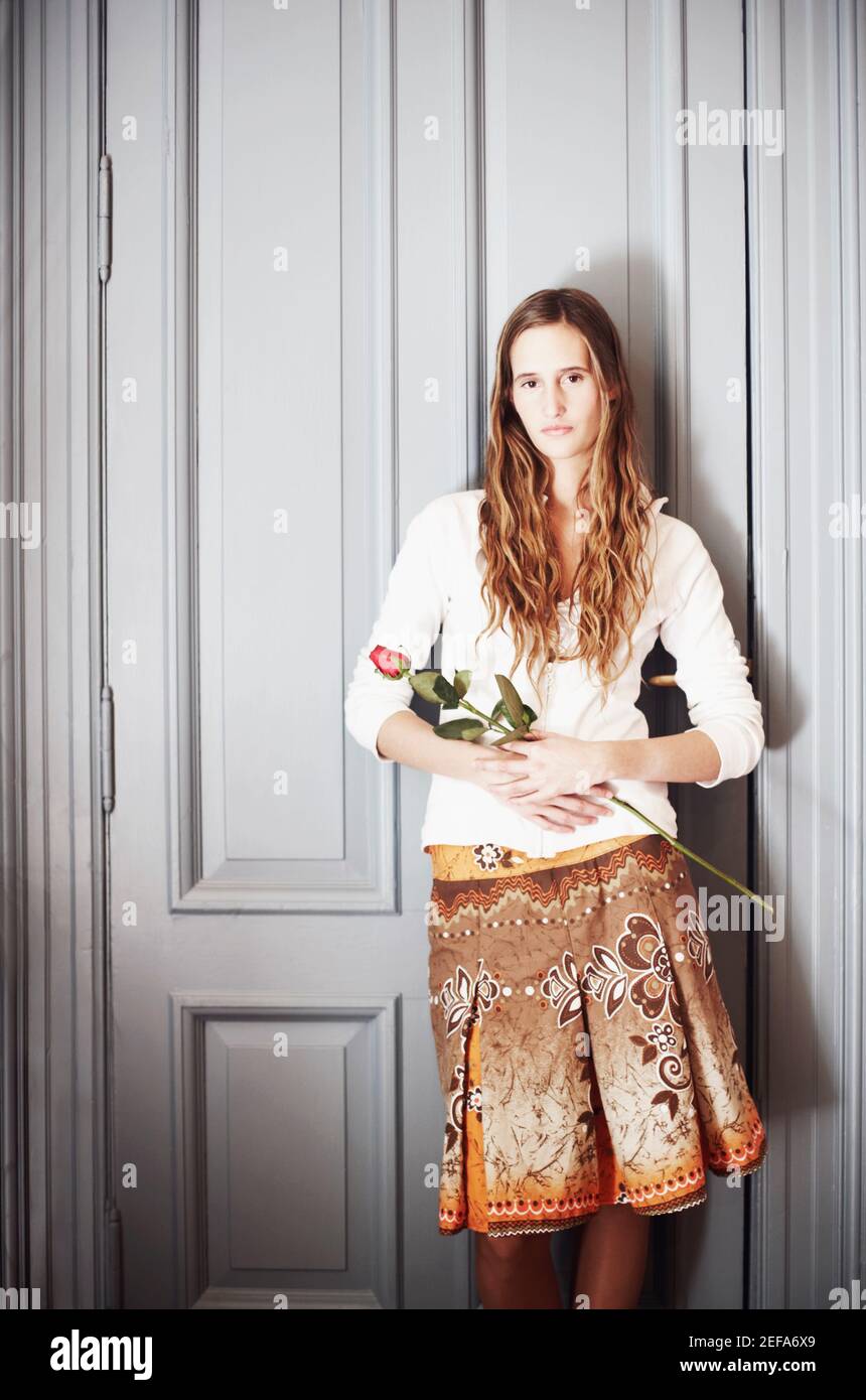 Portrait of a young woman holding a rose Stock Photo - Alamy