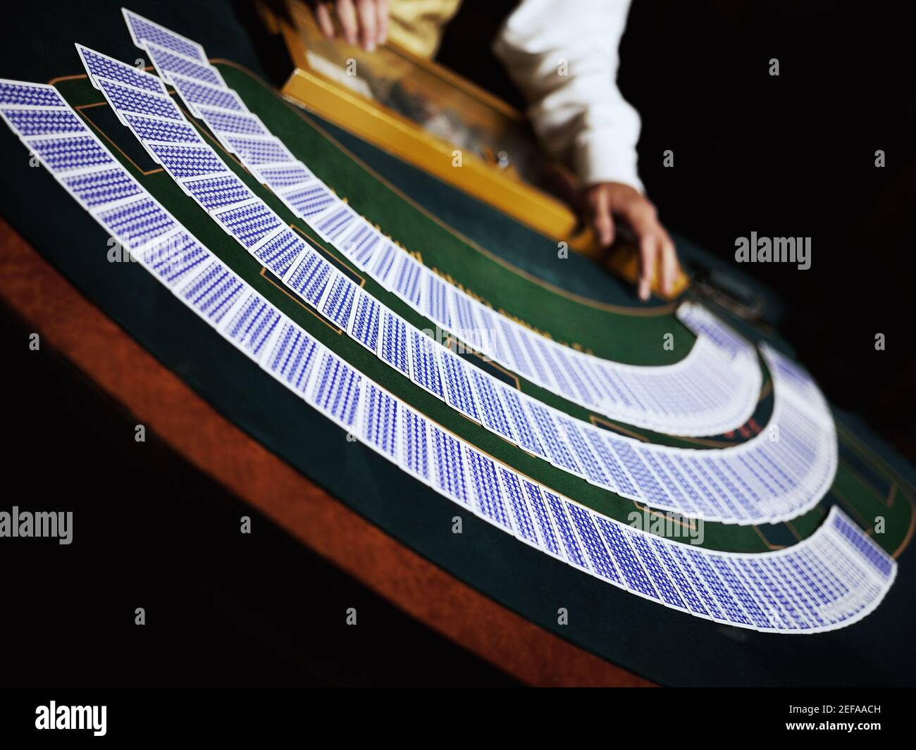 Casino worker dealing with playing cards on a gambling table Stock Photo